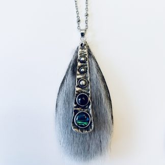 Pendentif en fourrure de phoque ornée de cabochons de grenat et de coquille d’ormeau — grande taille